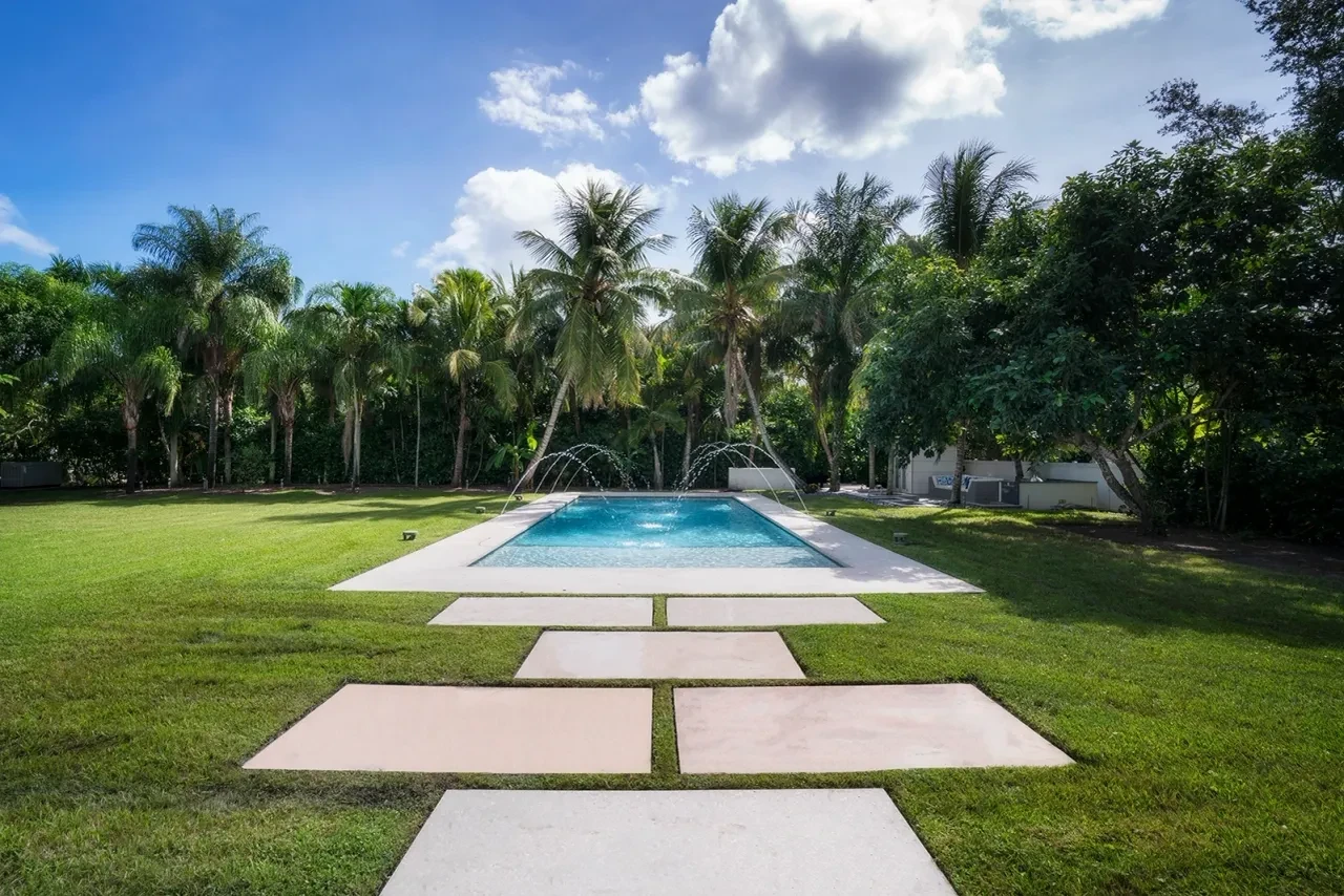 Luxury pool with stone pathway and tropical palms